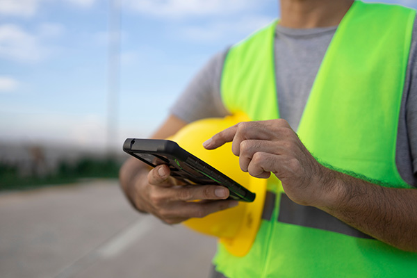 Un contratista usa su teléfono móvil en un sitio de trabajo.