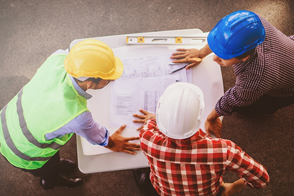 Un equipo revisando un plan en una obra de construcción.