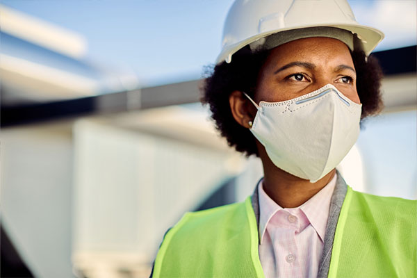 Una contratista de techado afroamericana con casco y chaleco de alta visibilidad