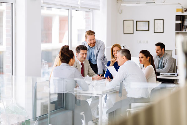 Equipo de ventas de servicios de techado reunidos en una oficina soleada