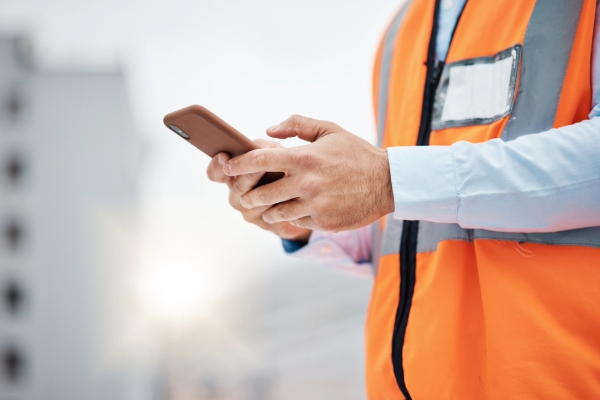 A contractor uses a smartphone on a jobsite.
